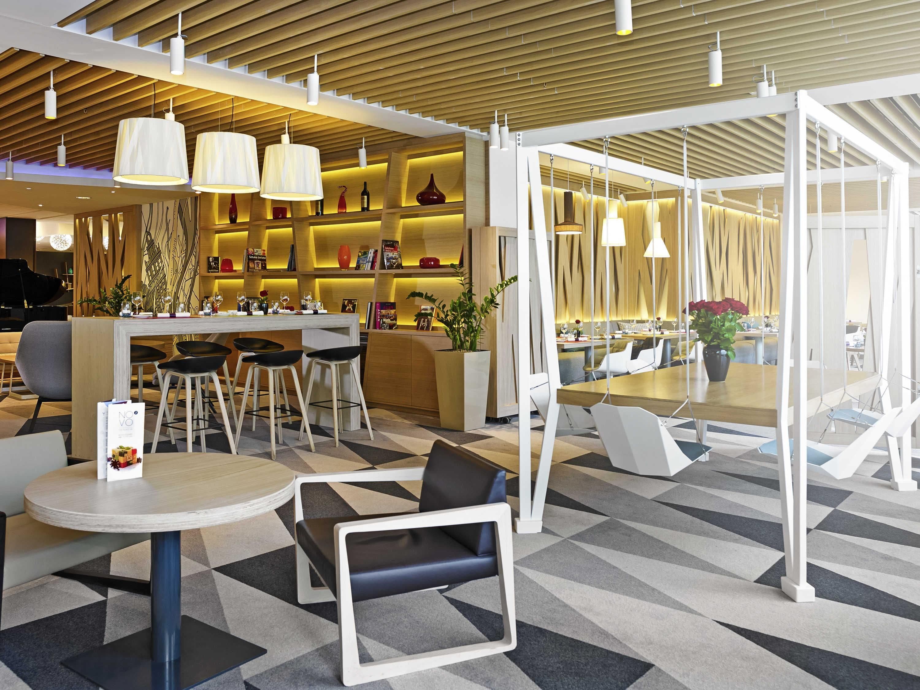 A modern interior with a bar area, seating, and a piano.
