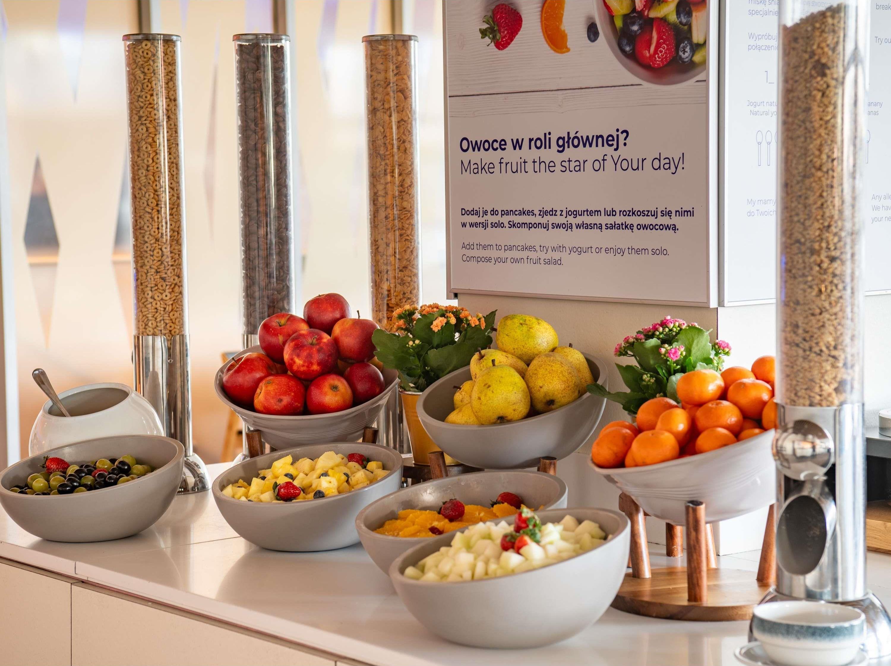 Un bufé de desayuno con diversas frutas y cereales.