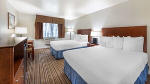 A hotel room with two beds, a desk, a chair, a lamp, and a window with curtains. - Best Western Capital City Inn (Sacramento)
