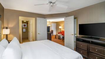A hotel room with a bed, a TV, a desk, and a chair.