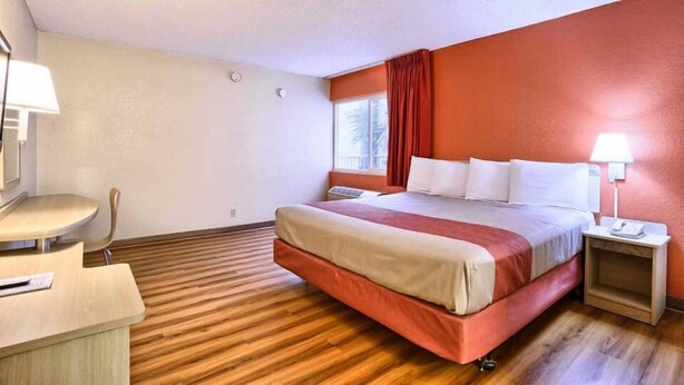 A hotel room with a bed, a desk, and a chair. - Cathedral Hill Hotel (San Francisco)