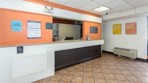 A reception area with a counter, a sign indicating closed circuit television and audio monitoring, and a wheelchair accessibility sign. - Cathedral Hill Hotel (San Francisco)