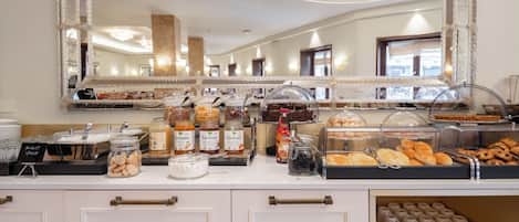 A buffet area with various food items and a large mirror above the counter.