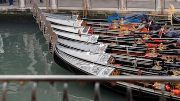 A row of gondolas docked at a canal.