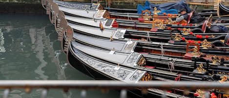 A row of gondolas docked at a canal.