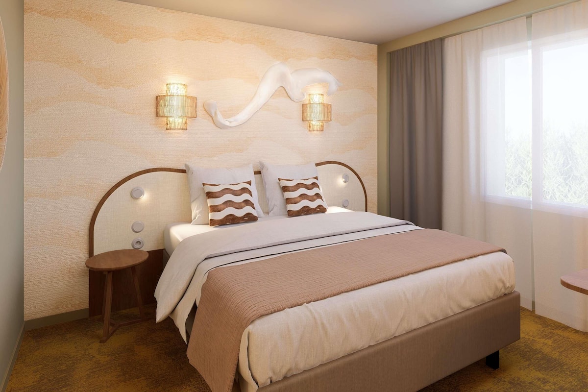 Une chambre dâhĂŽtel avec un grand lit, deux tables de chevet, un luminaire fixĂ© au mur et une fenĂȘtre avec des rideaux.