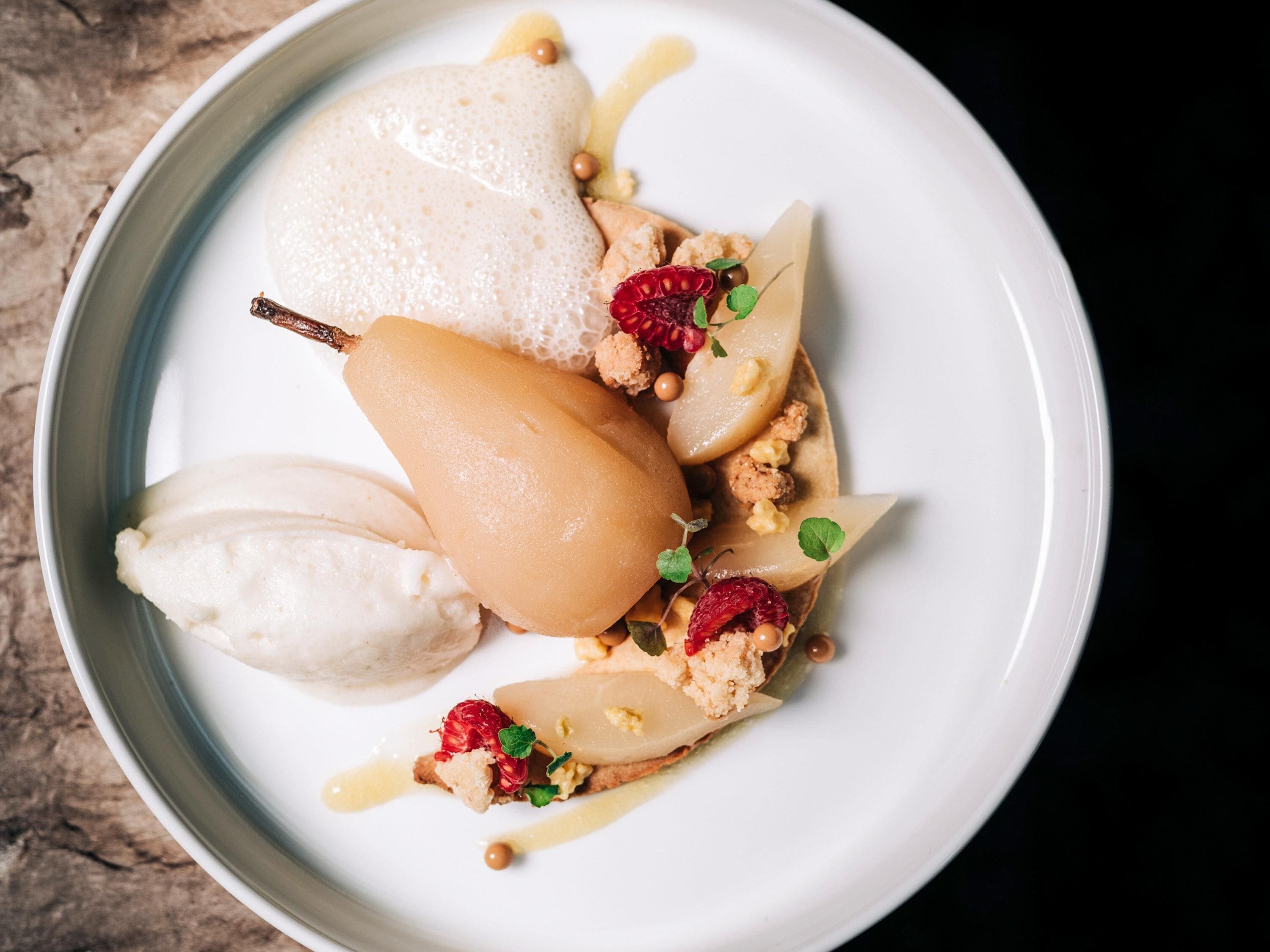 A dessert plate with various fruits and a pear.