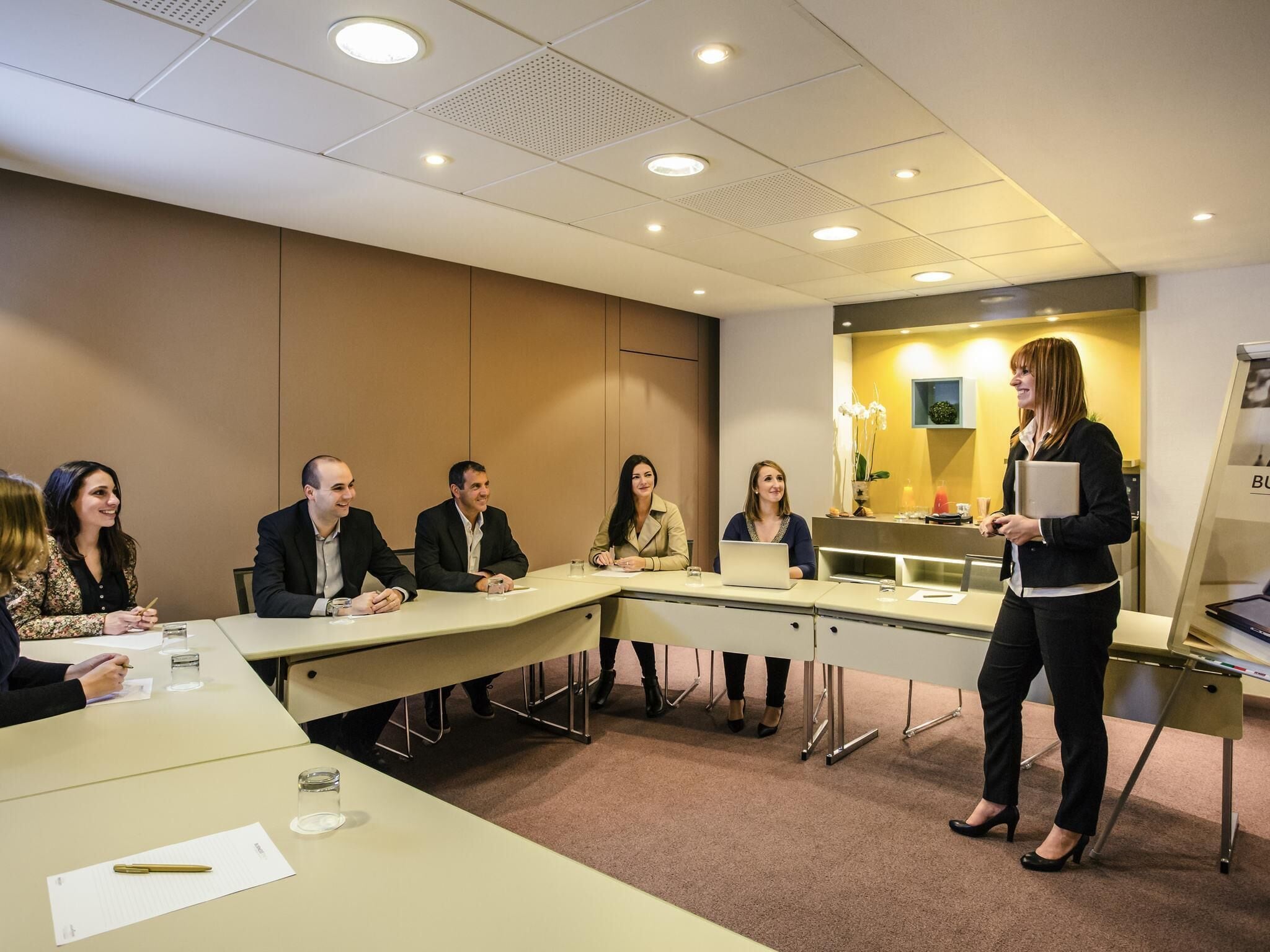 A conference room with a long table, chairs, and a podium.