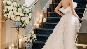 A grand staircase with a woman in a white dress.