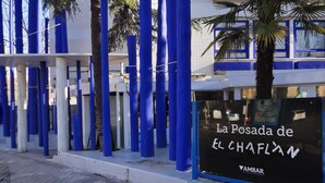 A building with blue vertical elements and a sign reading "La Posada de El Chaflan". - La Posada de El Chaflán (Madrid)