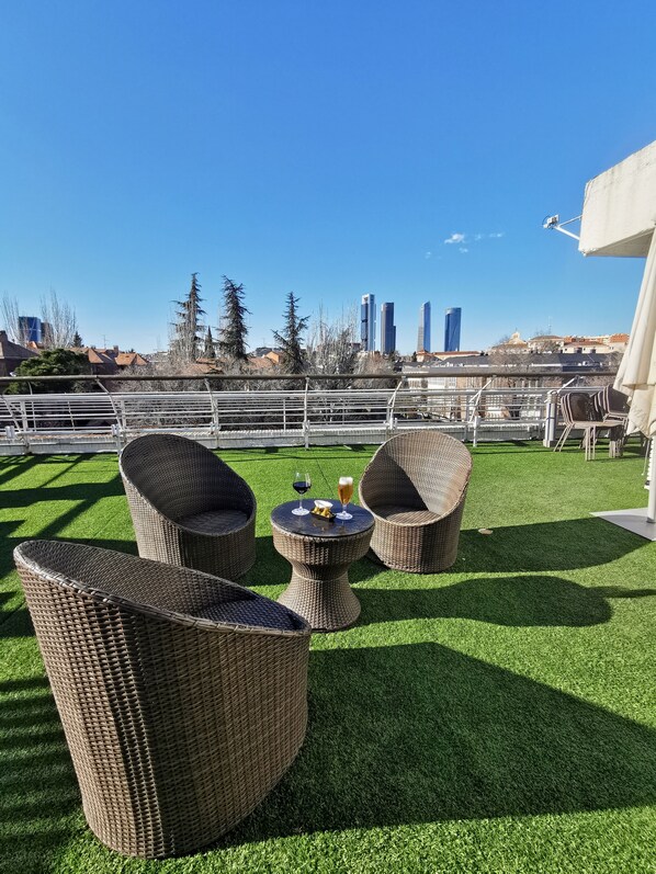 Relax in this outdoor seating area with wicker furniture, featuring a small table and two chairs.