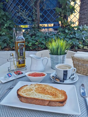 Enjoy a leisurely breakfast on this outdoor table, set with a variety of fresh foods and a potted plant.
