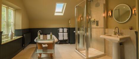 A modern bathroom with a glass shower enclosure, a vanity with a sink, and a large mirror.
