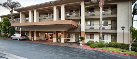 A multi-story hotel with a flat roof, balconies, and a covered entrance.