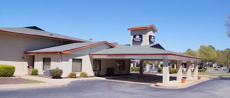 A Days Inn & Suites with a covered parking area and a small tower-like structure on the roof.