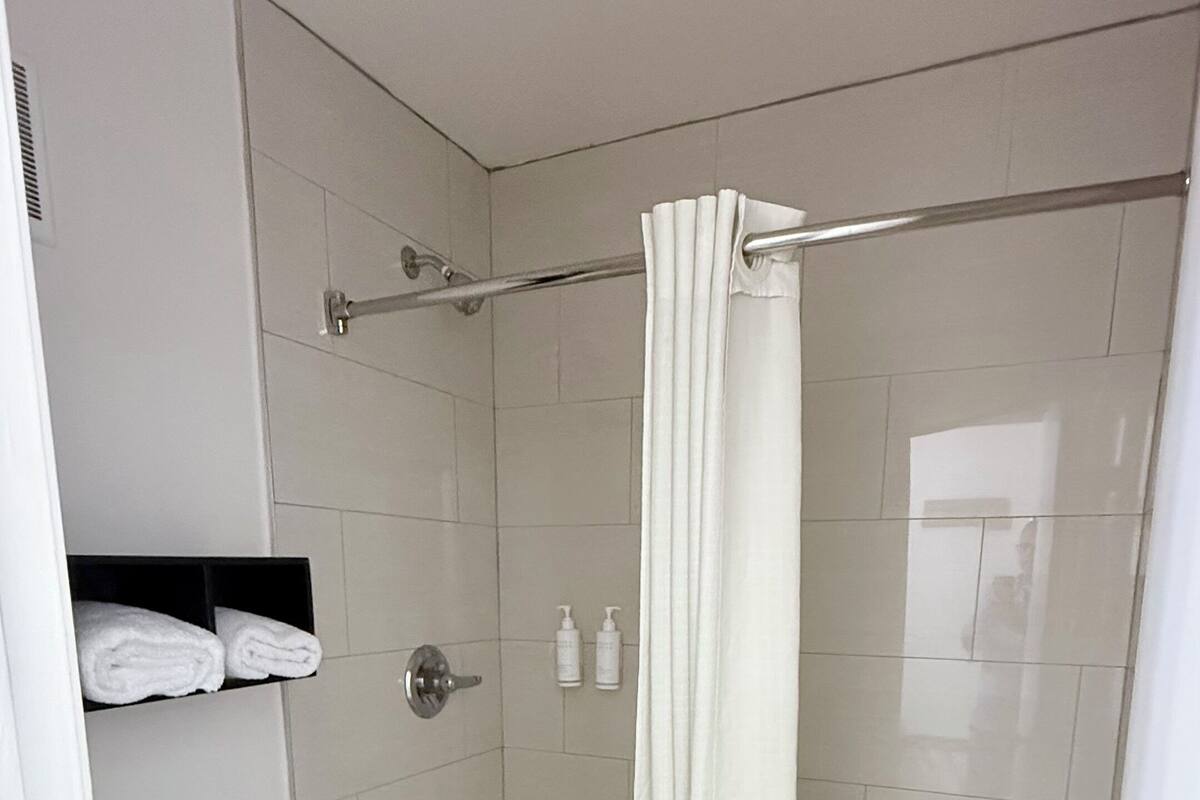 Ein modernes Badezimmer mit Toilette, Badewanne und Duschvorhang.