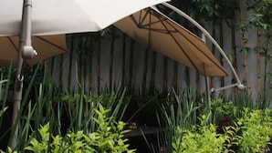 A sign for HOTEL EL EJECUTIVO by Reforma Avenue, with a large umbrella and lush greenery in the foreground. - Hotel El Ejecutivo by Reforma Avenue (Mexico City)