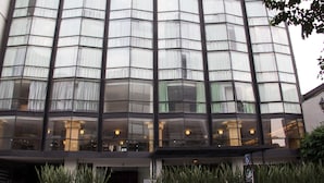 A modern building with a curved facade, large windows, and a sign indicating a handicap-accessible entrance. - Hotel El Ejecutivo by Reforma Avenue (Mexico City)