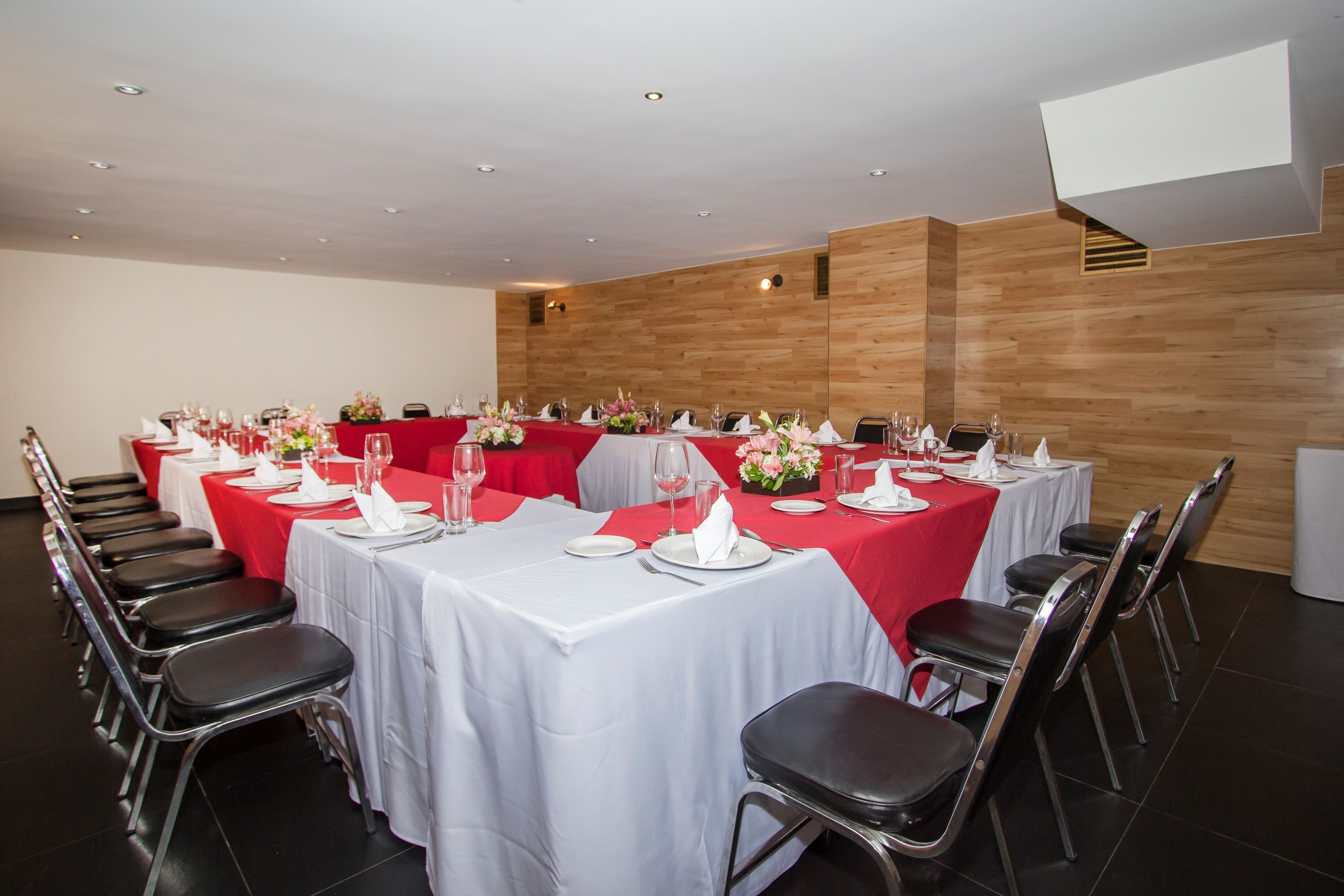 A conference room with multiple tables set for dining, equipped with chairs and table settings.
