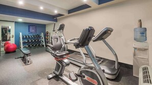 A gym with treadmills, a bench, and a water dispenser.