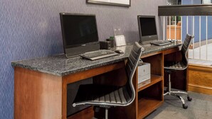 A workspace with two computer desks, each with a monitor, keyboard, and chair.