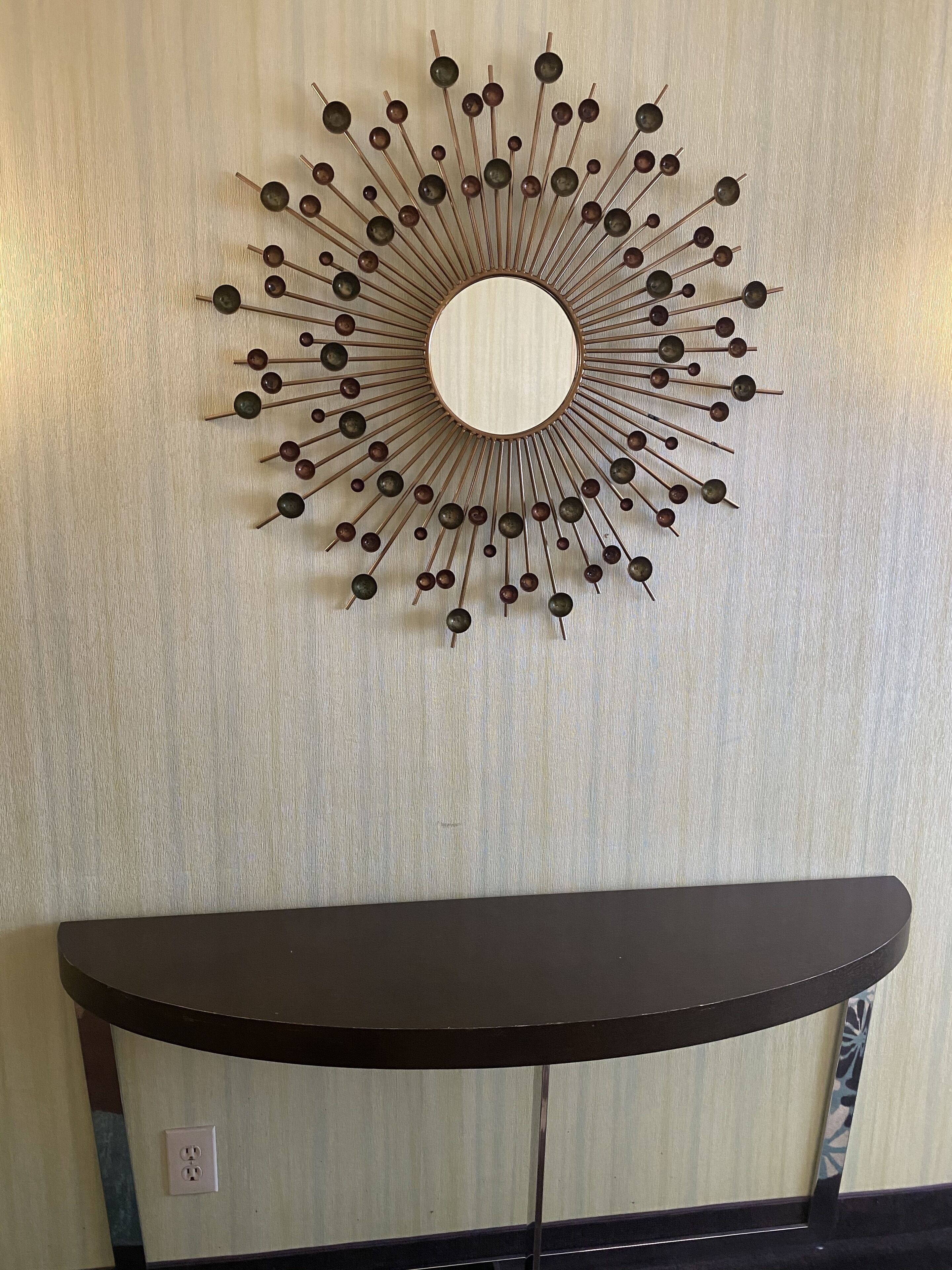 A wall-mounted decorative piece with a circular center and radiating elements.