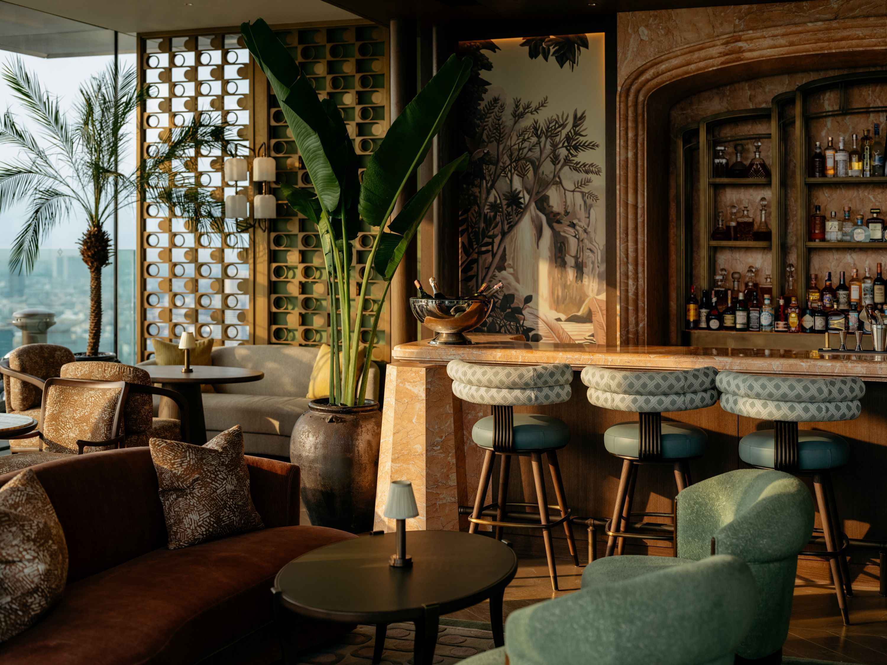 A bar area with a high bar counter, stools, and a wall of liquor bottles.