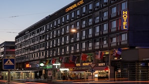 Un hotel de varios pisos con un letrero que dice "Continental Hotel" y "HOTEL" en luces de neón.
