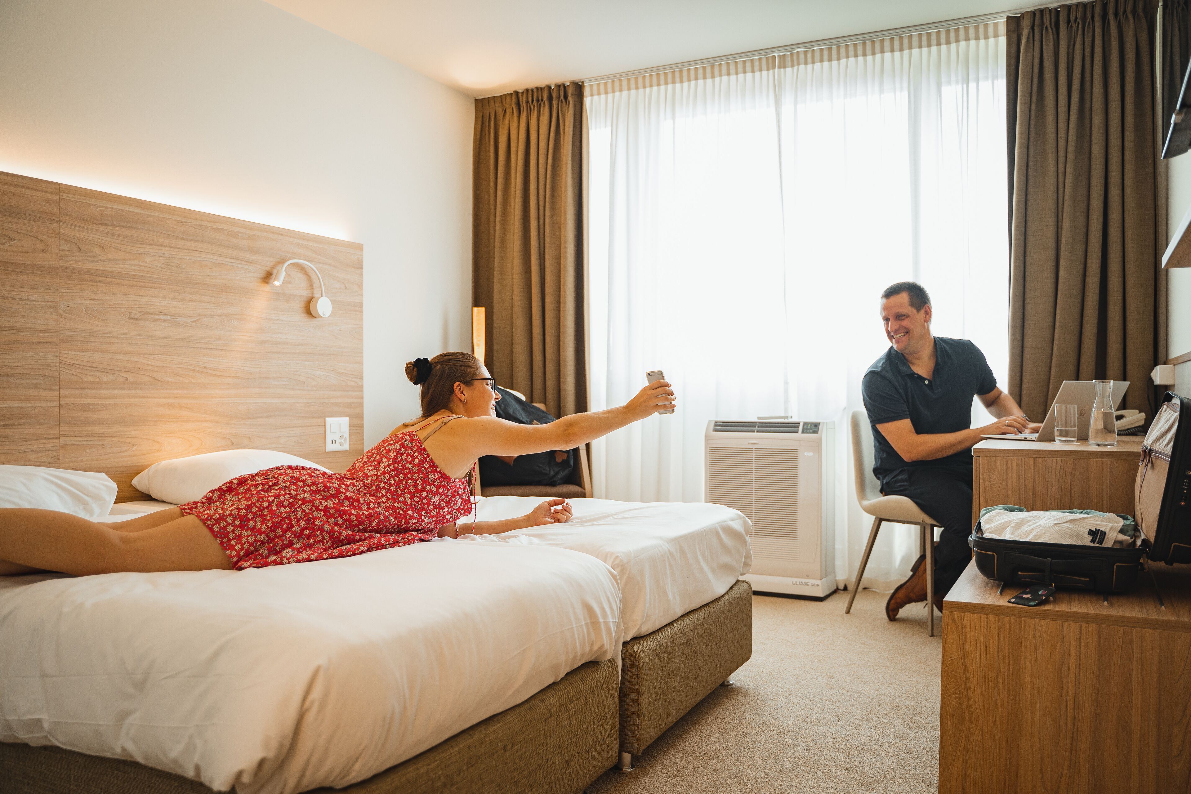 Ein Hotelzimmer mit Bett, Schreibtisch und Stuhl.