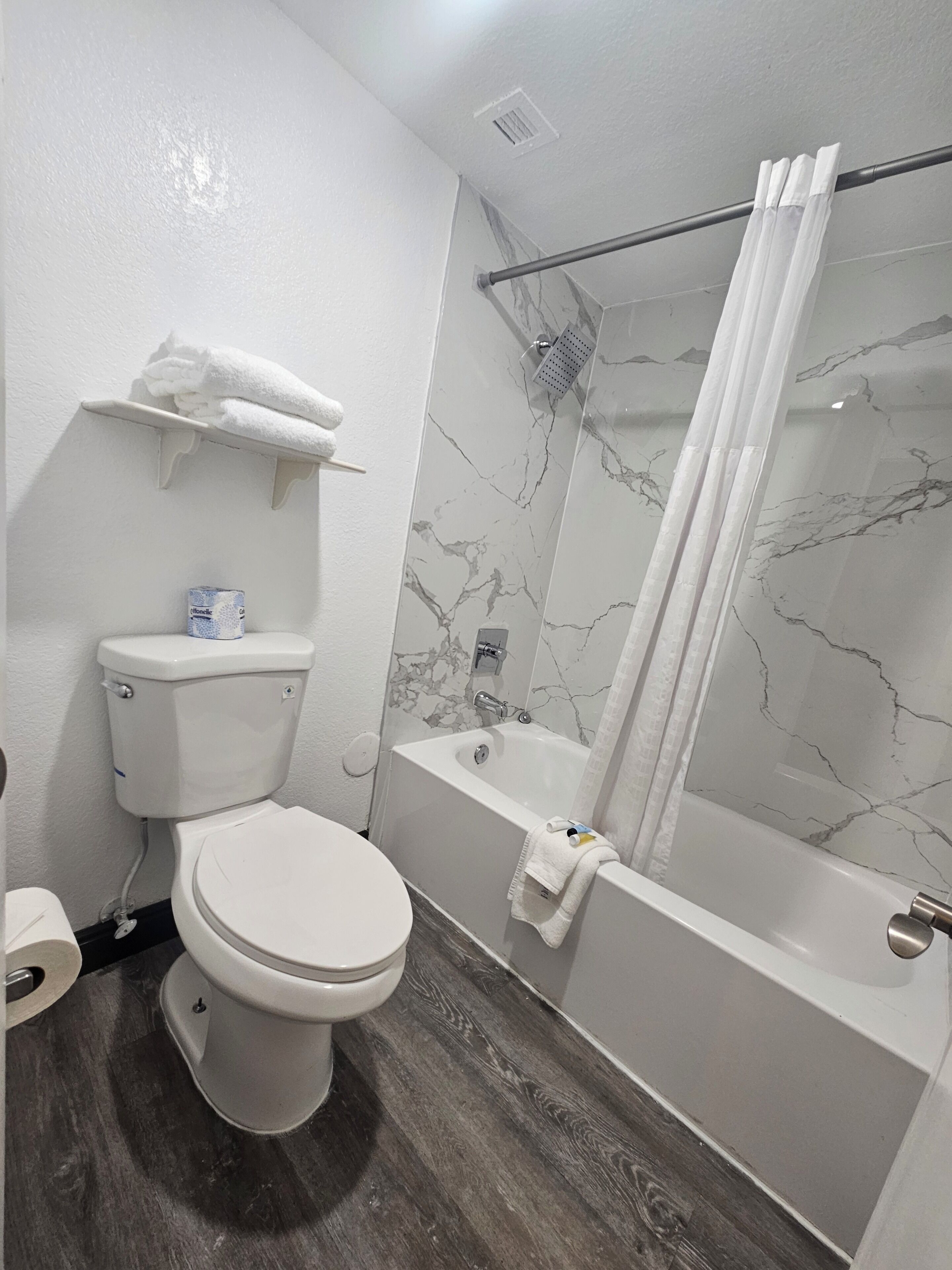 A bathroom with a toilet, a bathtub, and a shower curtain.