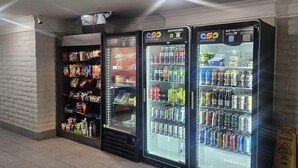 Trois distributeurs automatiques de boissons proposant une variété de boissons et d’en-cas.