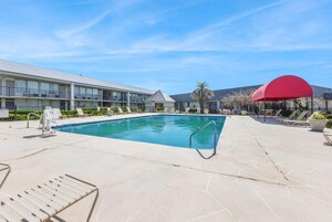 Una piscina al aire libre, camas de piscina gratis, sombrillas