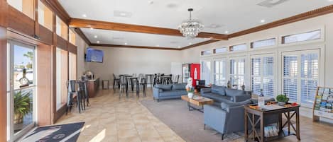 A spacious lobby with a reception desk, seating area, and large windows.