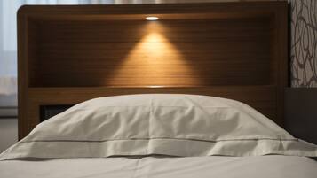 A bed with a wooden headboard and a bedside lamp.