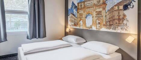 Una habitación de hotel con una cama, una ventana con cortinas, una lámpara de pared y un mural grande de un edificio histórico.