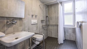 Moderni kylpyhuone, jossa on suihku, wc ja pesuallas.