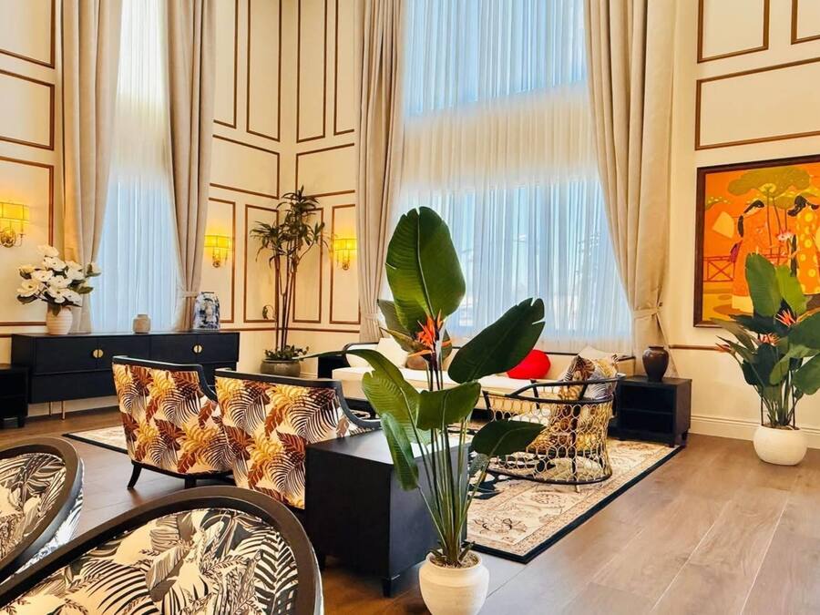 Un salón amplio con diseño moderno, que incluye un sofá grande, una mesa de centro y una planta en maceta.