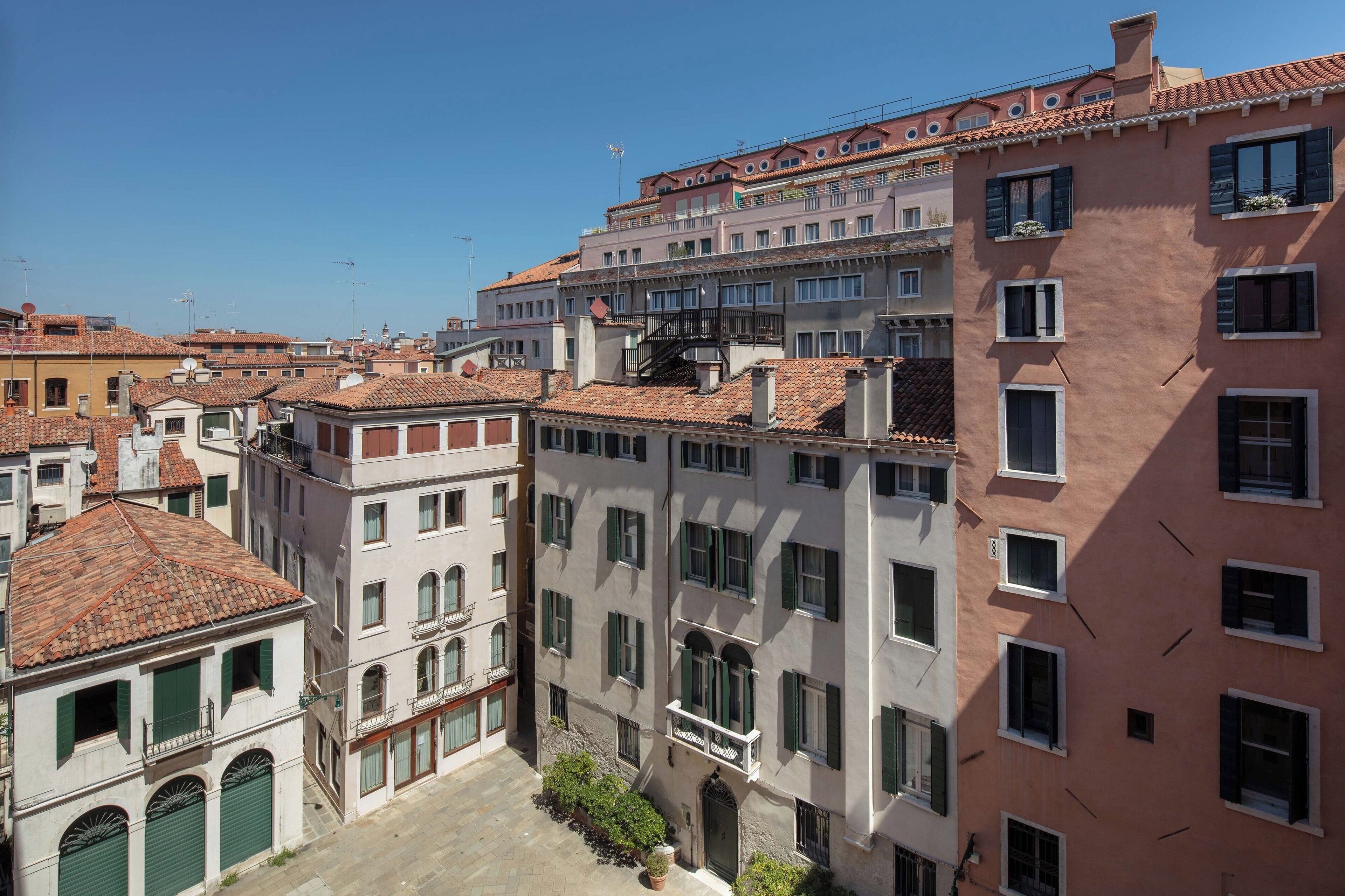 A narrow street with buildings featuring traditional architecture, including balconies and tiled roofs.