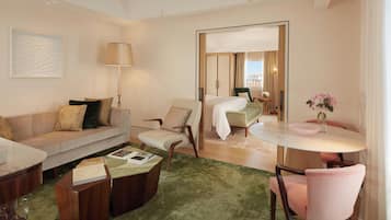 A modern hotel room with a living area, a dining table, and a bed.