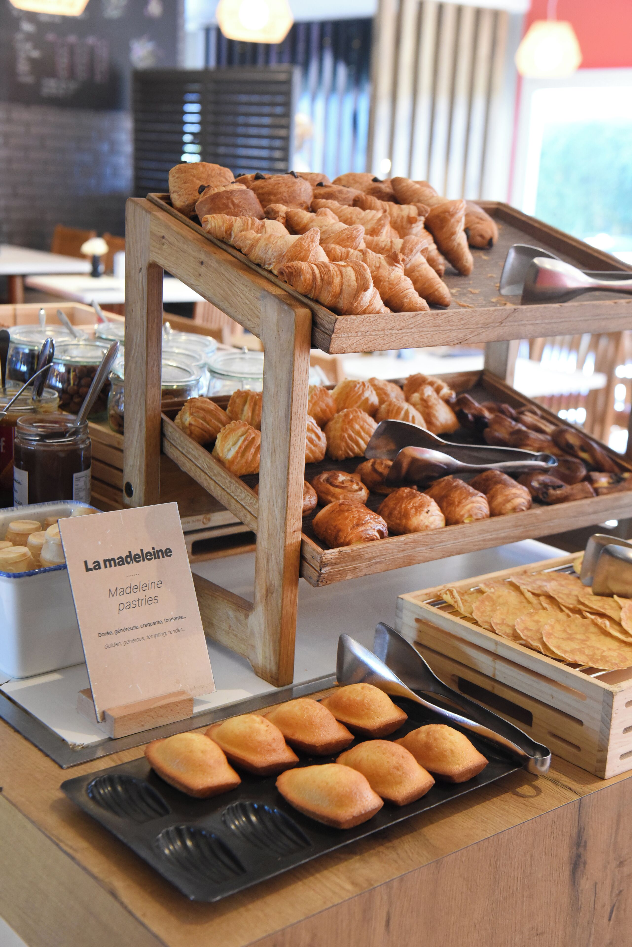 A bakery display with various pastries and a sign indicating 'La Madeleine'.