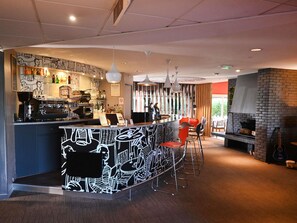 A bar area with a counter, bar stools, and a grill.