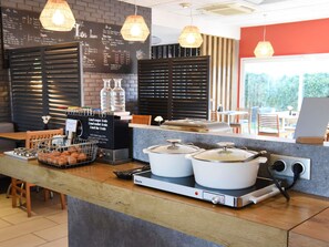 A breakfast bar with a chalkboard menu, kettles, and a coffee machine. - ibis Laval Le Relais d'Armor (Change)