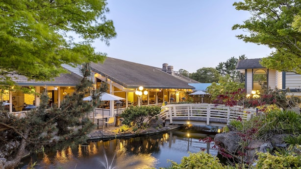 A lakeside hotel with a dining area, a bridge, and a pond. - Seacliff Inn Aptos, Tapestry Collection by Hilton (Aptos)