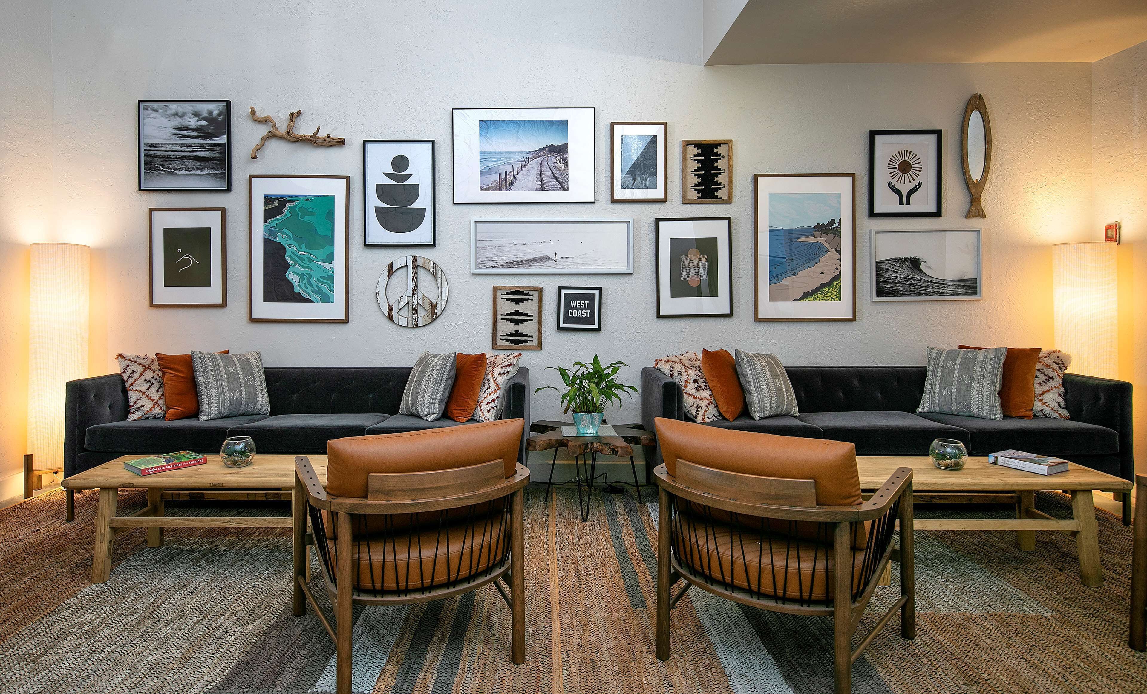 A living room with two sofas, a coffee table, and a rug. There are framed artworks on the wall.