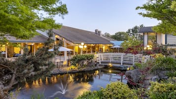 Un hotel junto al lago con terraza al aire libre y un puente sobre el agua.