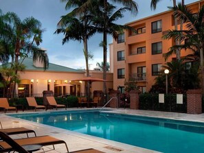 Een buitenzwembad en ligstoelen