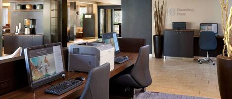 A modern office space with desks, computers, and a 'Boarding Pass' sign on the wall.
