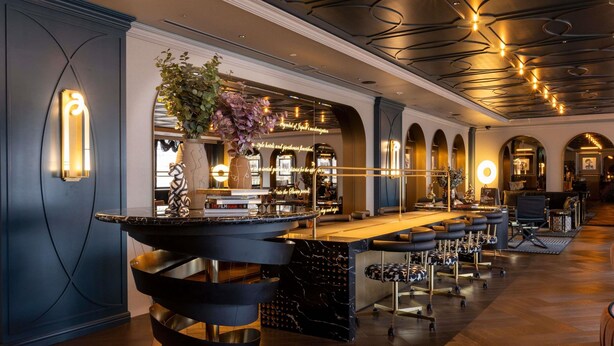 A modern bar area with a central bar, seating, and a decorative plant. - Mercure Tokyo Hibiya (Tokyo)
