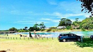 A beach with a fenced area, a parked car, and people enjoying the water. - Best Western Burnie Murchison Lodge (Somerset)