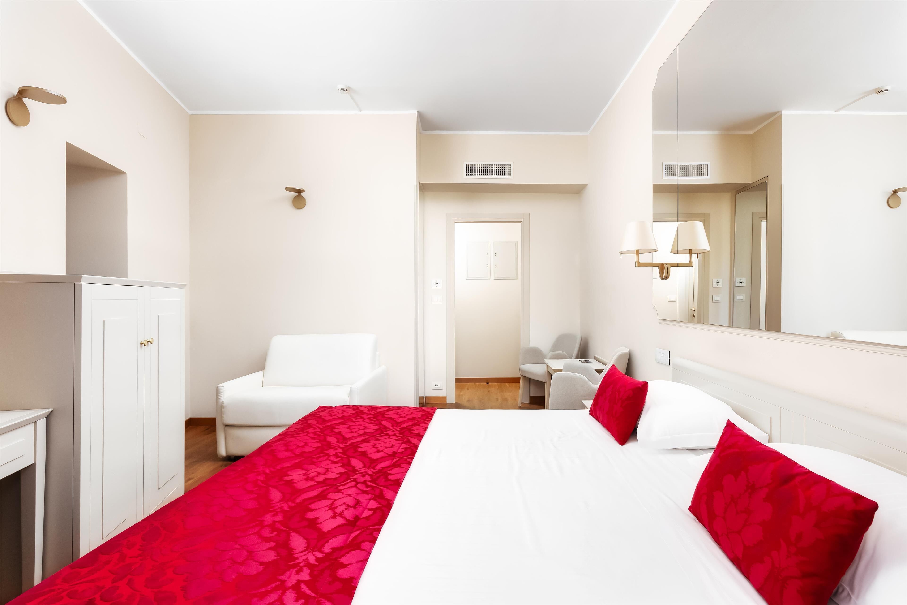 Une chambre d’hôtel comprenant un lit, un bureau, une chaise et une armoire.